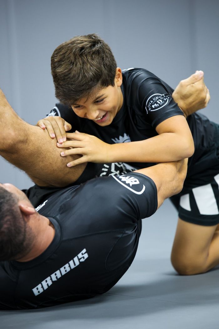 A young Brabus Academy student tying his belt with a training partner